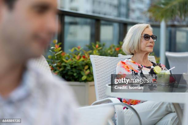 elegant old lady drinking a caipirinha - confortável stock pictures, royalty-free photos & images