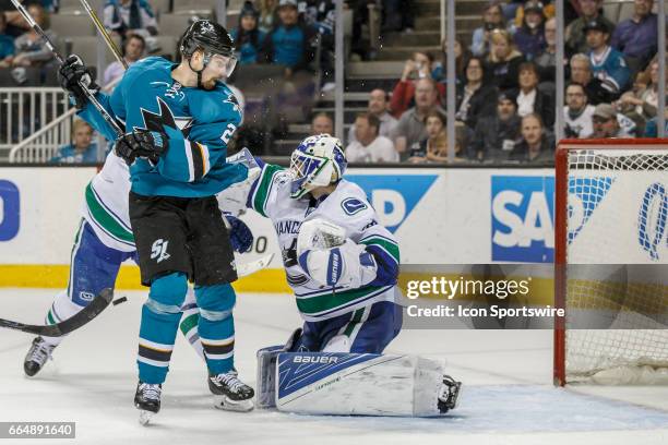 Vancouver Canucks goalie Richard Bachman makes a save as San Jose Sharks right wing Marcus Sorensen looks for the rebound during the third period of...