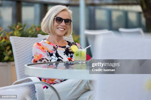 elegante oude dame drinken een caipirinha - relaxamento stockfoto's en -beelden