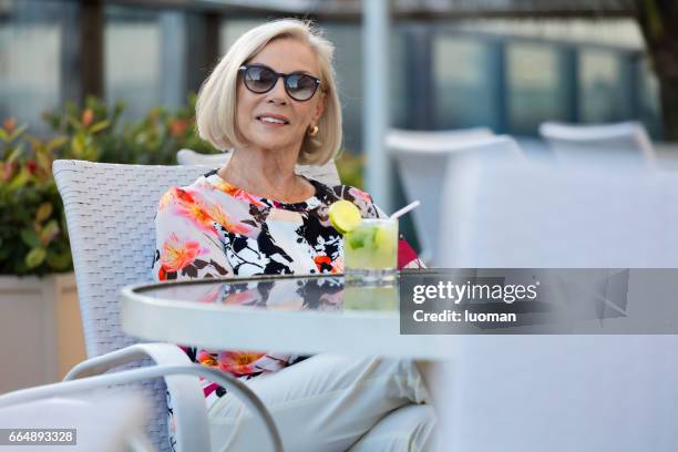 elegante oude dame drinken een caipirinha - foco seletivo stockfoto's en -beelden