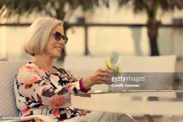 elegante oude dame drinken een caipirinha - etnia caucasiana stockfoto's en -beelden