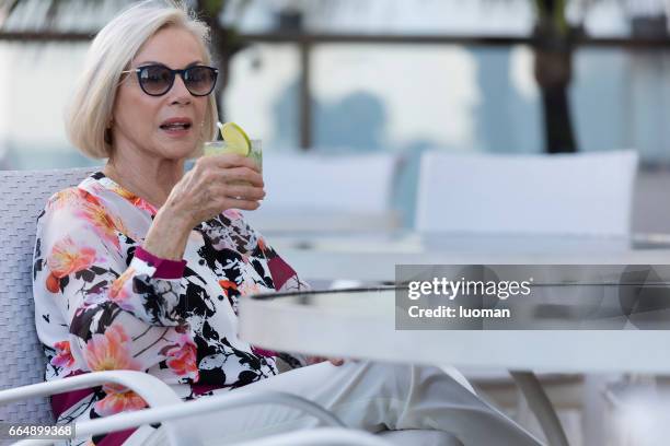 elegant old lady drinking a caipirinha - 70 anos stock pictures, royalty-free photos & images