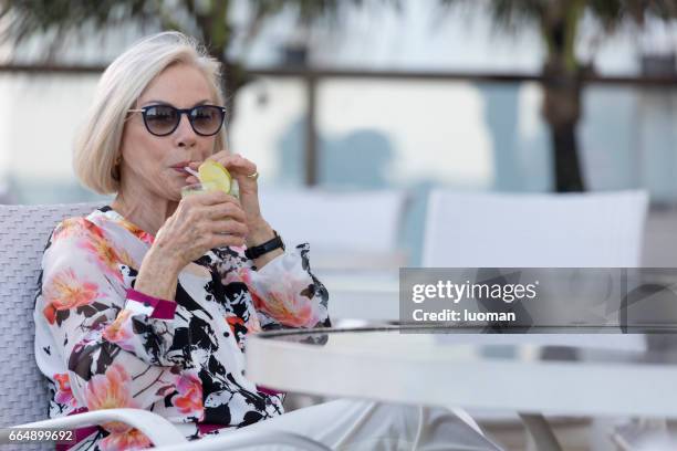 elegant old lady drinking a caipirinha - cadeira stock pictures, royalty-free photos & images