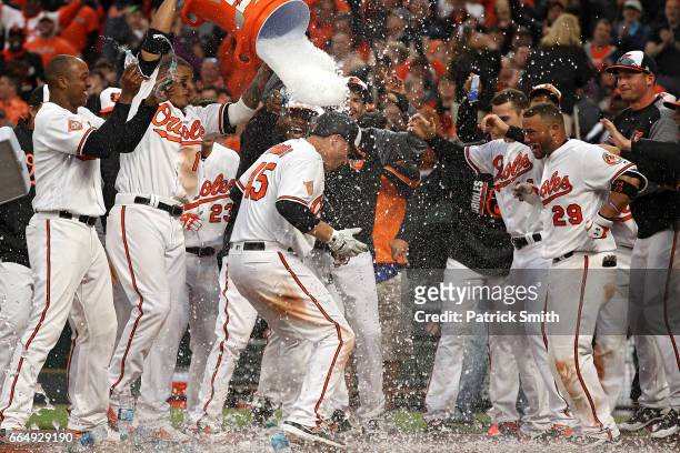 Mark Trumbo of the Baltimore Orioles is greeted at home plate after hitting a walk-off home run against the Toronto Blue Jays during the eleventh...