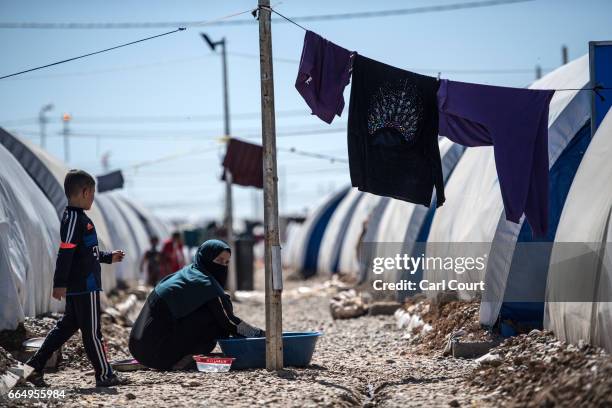 Woman washes clothes in Hamam al-Alil refugee camp where large numbers of people have settled after being displaced by fighting during the offensive...