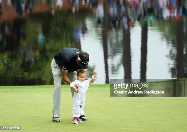 Bubba Watson of the United States helps his daughter Dakota putt during the Par 3 Contest prior to the start of the 2017 Masters Tournament at...