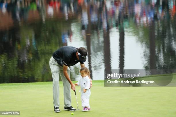 Bubba Watson of the United States helps his daughter Dakota putt during the Par 3 Contest prior to the start of the 2017 Masters Tournament at...