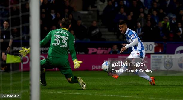 Elias Kachunga of Huddersfield scores the opening goal past Michael McGovern of Norwich during the Sky Bet Championship match between Huddersfield...