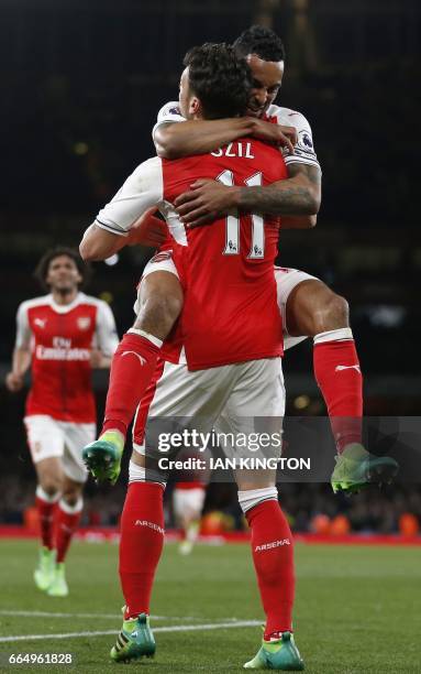 Arsenal's English midfielder Theo Walcott celebrates with Arsenal's German midfielder Mesut Ozil after scoring their second goal during the English...