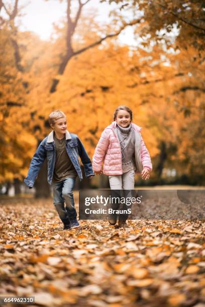 full length of two happy kids running in the park. - s sister sister stock pictures, royalty-free photos & images