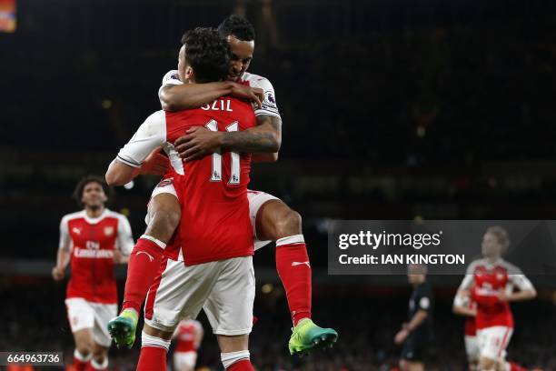 Arsenal's English midfielder Theo Walcott celebrates with Arsenal's German midfielder Mesut Ozil after scoring their second goal during the English...