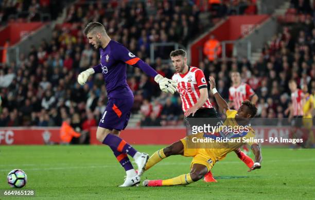 Southampton goalkeeper Fraser Forster takes the ball away from Crystal Palace's Wilfried Zaha during the Premier League match at the KCOM Stadium,...