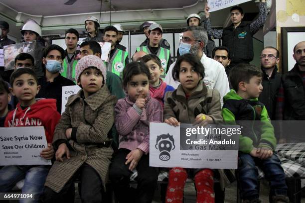 People gather to protest Assad regime forces' suspected chemical gas attack in the opposition-held Syrian province of Idlib, in Eastern Goutha...