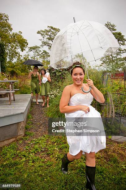 bride ready and on the way in light summer rain - wedding umbrella stock pictures, royalty-free photos & images