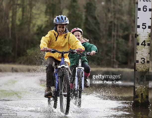 two children riding over ford on bikes - 12 years old girls stock pictures, royalty-free photos & images