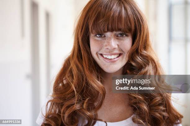 laughing redhead in front of a window - woman unique features stock-fotos und bilder