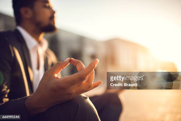close up of a businessman exercising yoga at sunset. - businessman meditating stock pictures, royalty-free photos & images