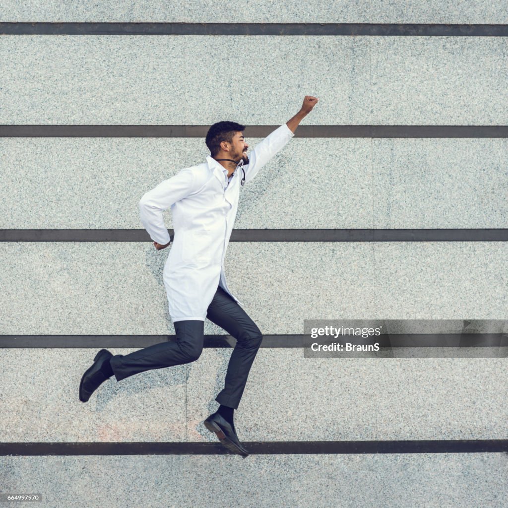 Médecin afro-américain ludique battant contre le mur.