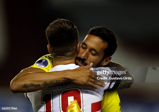 Jonas Gutierrez of Defensa y Justicia and Julio Buffarini of Sao Paulo embrace prior a first leg match between Defensa y Justicia and Sao Paulo as...