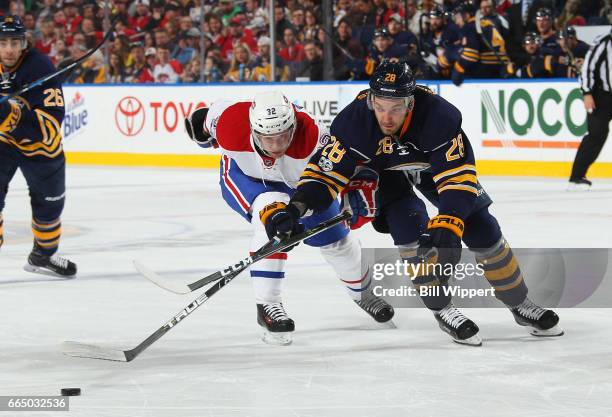 Zemgus Girgensons of the Buffalo Sabres battles for the puck against Brian Flynn of the Montreal Canadiens during an NHL game at the KeyBank Center...