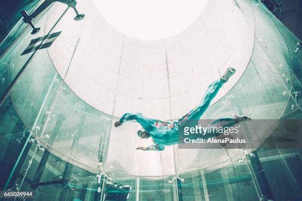 indoors skydiving - one young man practising freefall simulation - indoor skydive stock pictures, royalty-free photos & images