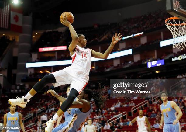 Troy Williams of the Houston Rockets drives to the basket and is fouled by Kenneth Faried of the Denver Nuggets in the first half at Toyota Center on...