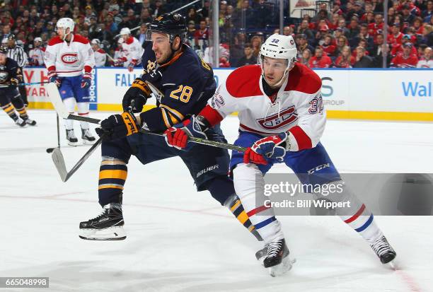 Zemgus Girgensons of the Buffalo Sabres and Brian Flynn of the Montreal Canadiens battle for the puck during an NHL game at the KeyBank Center on...