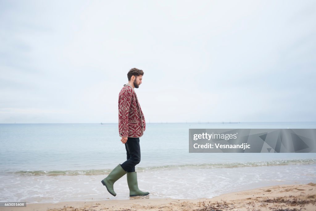 Man lopen op het strand