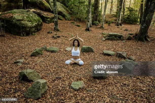woman in yoga lotus pose in forest - stone circle stock pictures, royalty-free photos & images