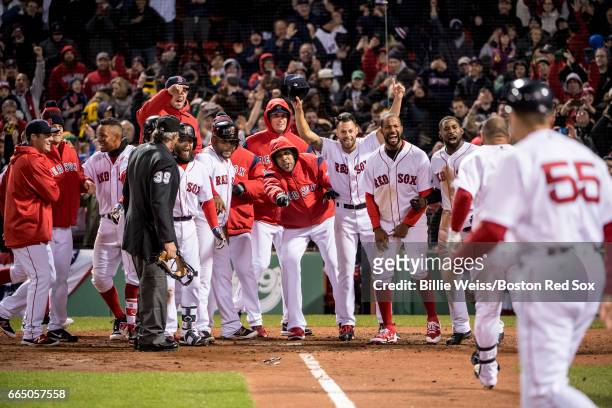 Sandy Leon of the Boston Red Sox is mobbed by teammates after hitting a walk off three run home run during the twelfth inning of a game against the...