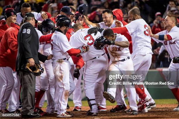 Sandy Leon of the Boston Red Sox is mobbed by teammates after hitting a walk off three run home run during the twelfth inning of a game against the...