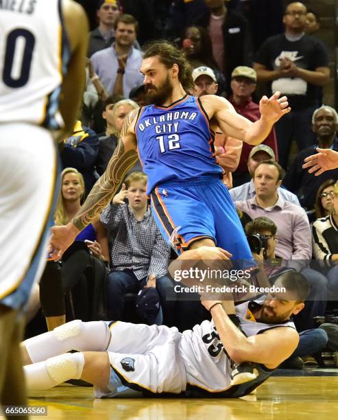 Marc Gasol of the Memphis Grizzlies grabs the leg of Steven Adams of the Oklahoma City Thunder during the second half of a 103-100 Thunder victory at...