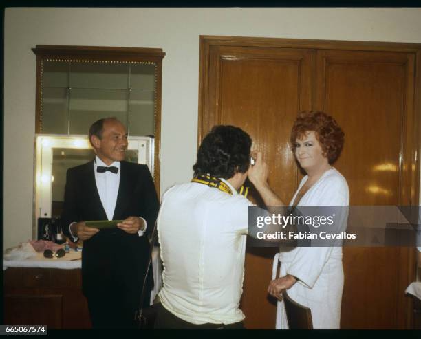 French actor Michel Serrault poses for a photographer as a transvestite with french actor Marcel Bozzuffi in tuxedo, on the set of french director...