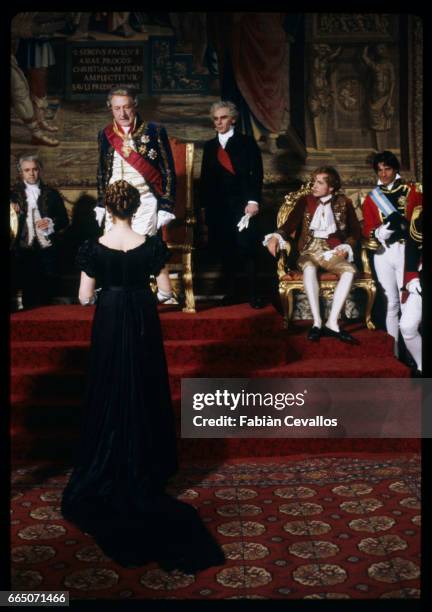 Actress Marthe Keller, with her back on the camera, looks up to Georges Wilson, playing the Prince of Parma, and Gian Maria Volonte, playing Count...
