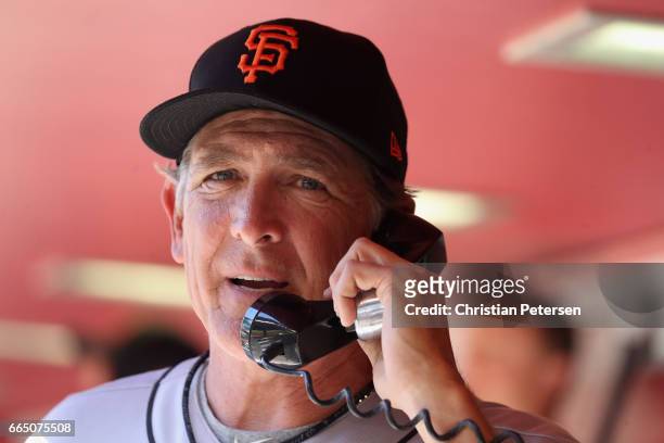 Pitching coach Dave Righetti of the San Francisco Giants makes a call to the bullpen during the MLB opening day game against the Arizona Diamondbacks...