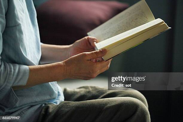 hands of mature woman reading book,close up - book close up stock-fotos und bilder