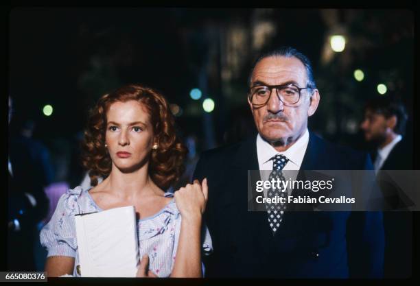 In a scene from the movie "Cento Giorni a Palermo", directed by Giuseppe Ferrara, actor Lino Ventura, wearing glasses, a dark suit, a shirt and a...