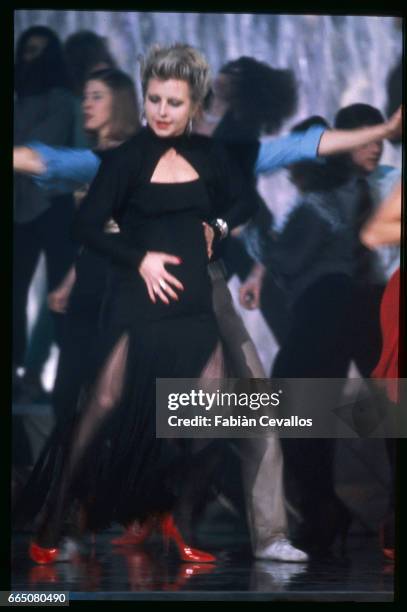 German actress Hanna Schygulla dances in a black dress among a group of other people in a scene of Italian director Marco Ferreri's film Il Futuro e...