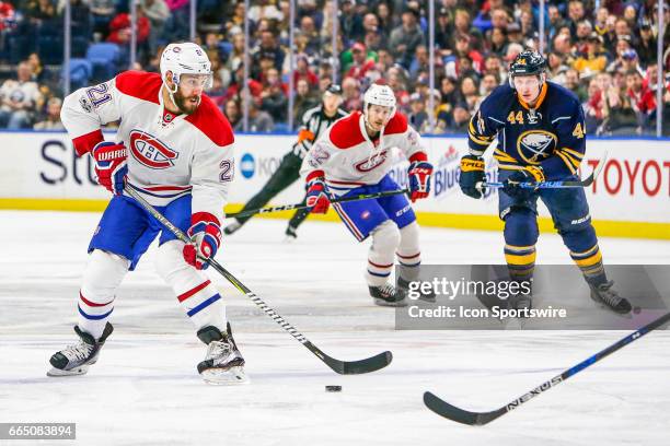 Montreal Canadiens Left Wing Dwight King looks to pass as Montreal Canadiens Winger Brian Flynn and Buffalo Sabres Winger Nicolas Deslauriers look on...