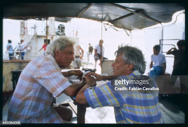 The American actor Samuel Fuller and director Jacques Perrin on the deck of a ship, discuss the making of the 1988 French TV series Medecins des...
