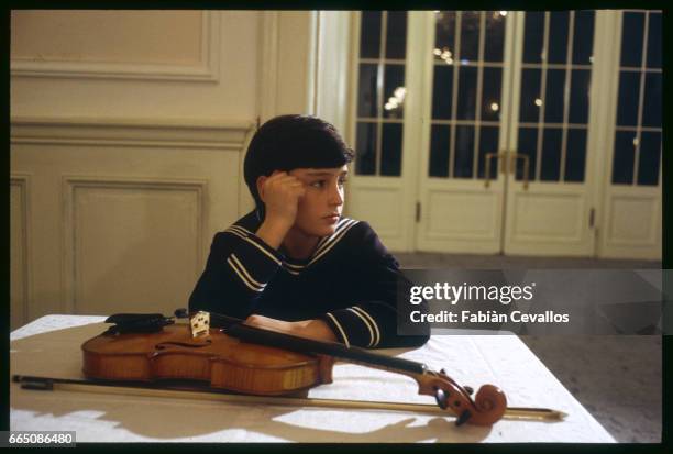 Young actor David Eberts sits with a violin on the set of the 1988 movie Burning Secret, or Brennendes Geheimnis in German. Directed by British...