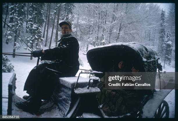 American actress Faye Dunaway and young actor David Eberts ride in a carriage driven by an actor on the set of the 1988 movie Burning Secret, or...