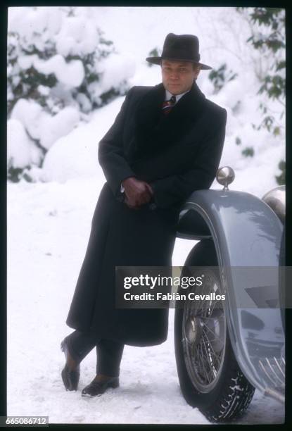 Austrian actor Klaus Maria Brandauer leans on a vintage automobile on the set of the 1988 movie Burning Secret, or Brennendes Geheimnis in German....