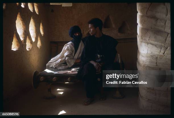 American actress Debra Winger sits next to actor Eric Vu-An in a half-lit room, during the shooting of the movie Un The au Sahara, or Il Te Nel...