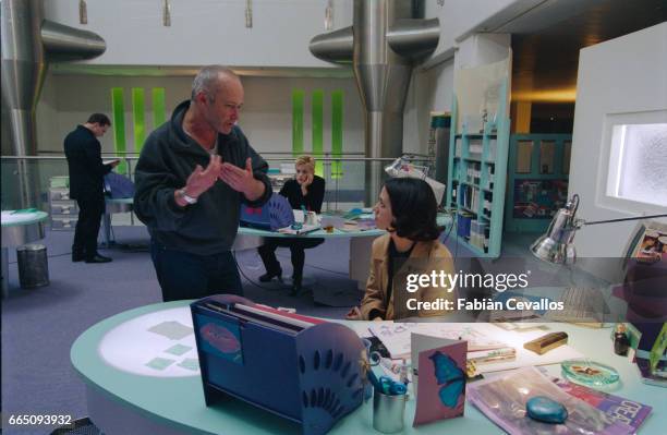 Director Michael Radford gestures and gives advice to Italian Actress Asia Argento in a modern office work scene on the set of the movie B. Monkey....