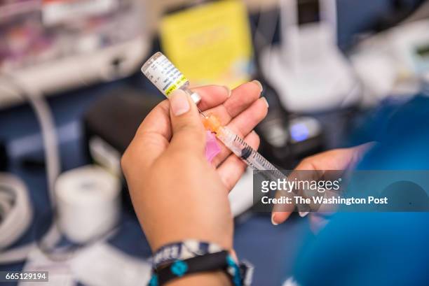 Certified medical assistant Karla Huerta fills a needle with the drug Gardasil, used for HPV vaccinations, at Amistad Community Health Center in...
