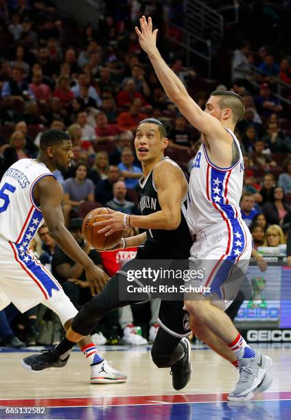 Jeremy Lin of the Brooklyn Nets drives to the basket as T.J. McConnell of the Philadelphia 76ers defends in the first half during an NBA game at...