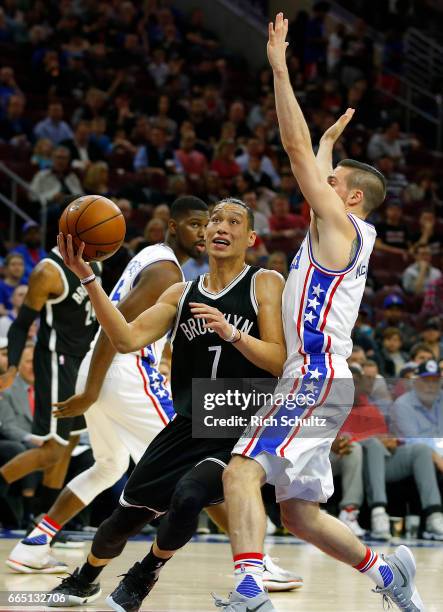 Jeremy Lin of the Brooklyn Nets drives to the basket as T.J. McConnell of the Philadelphia 76ers defends in the first half during an NBA game at...