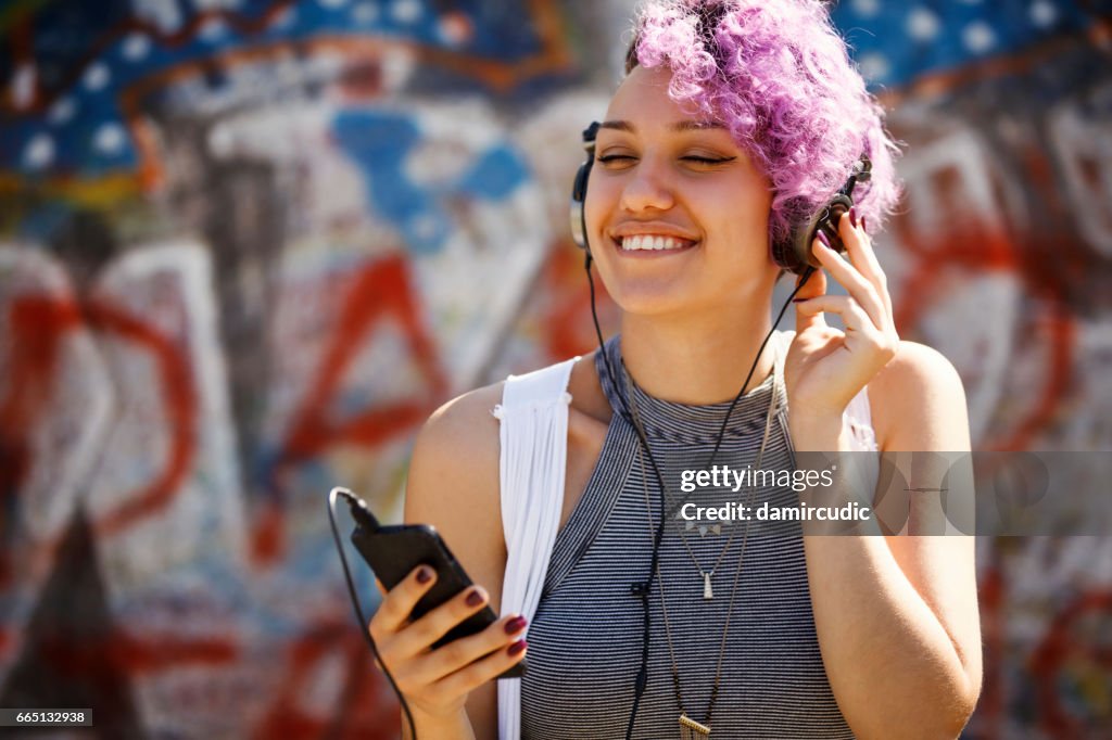 Hipster girl with headphones listening to music outdoor