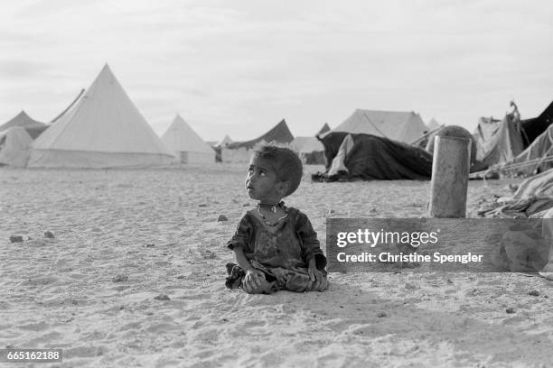 Young child sits alone in a camp in the western Sahara desert. There area has been in territorial dispute between Western Sahara and Morocco since...